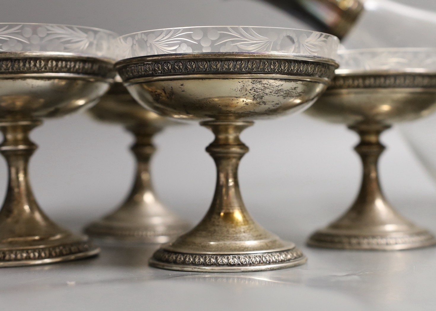 A set of eight sterling dessert coupes with glass inserts, height 6mm, together with a modern silver mounted decanter, by Asprey & Co Ltd (lacking stopper - one glass insert missing)